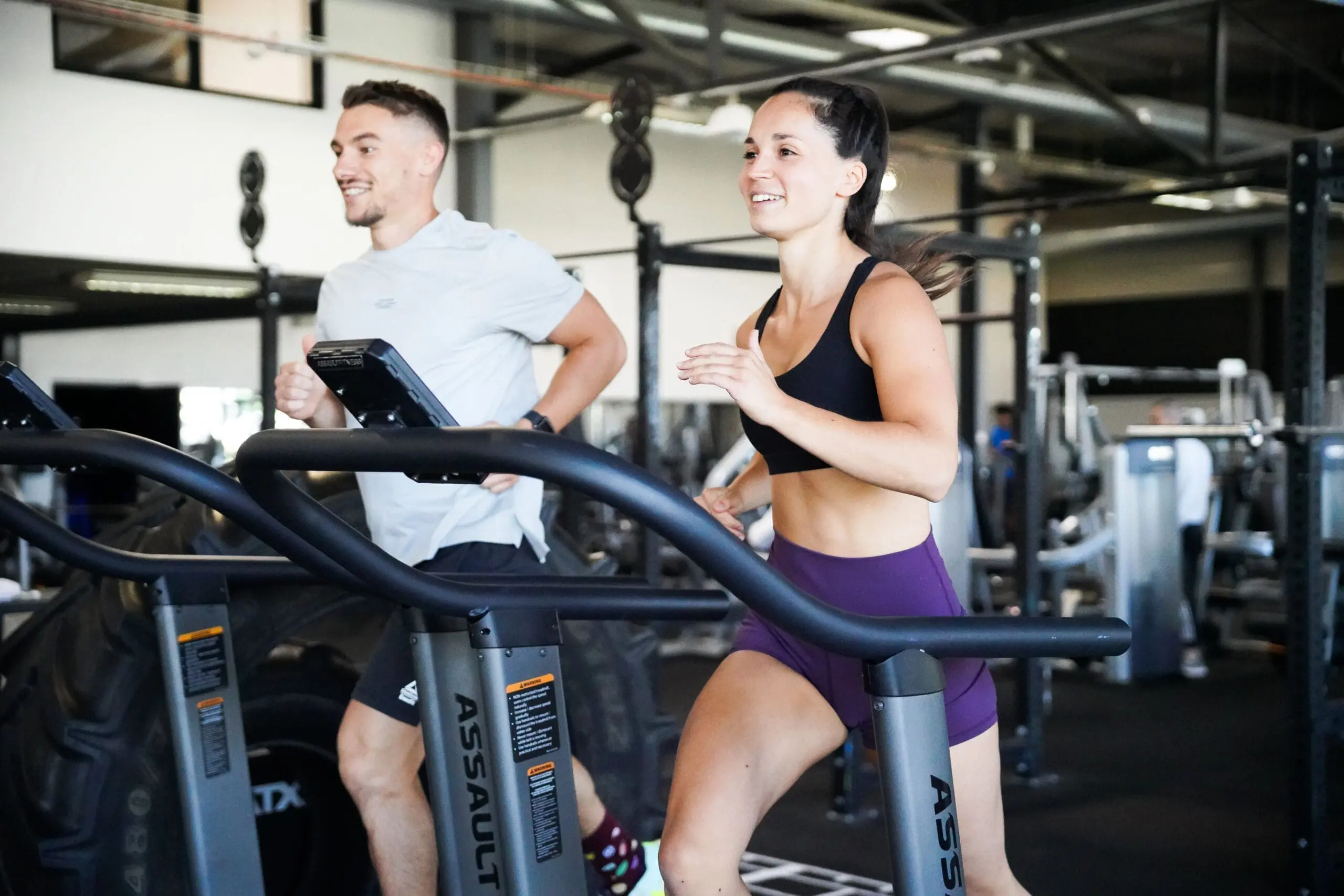 un homme et une femme courant sur des tapis de course